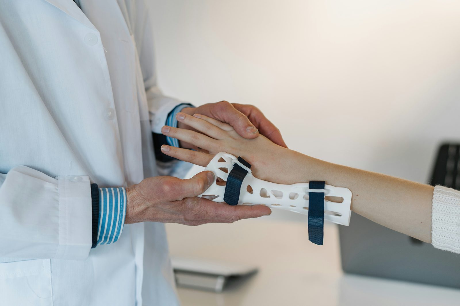 Doctor fitting a hand splint as part of rehabilitation